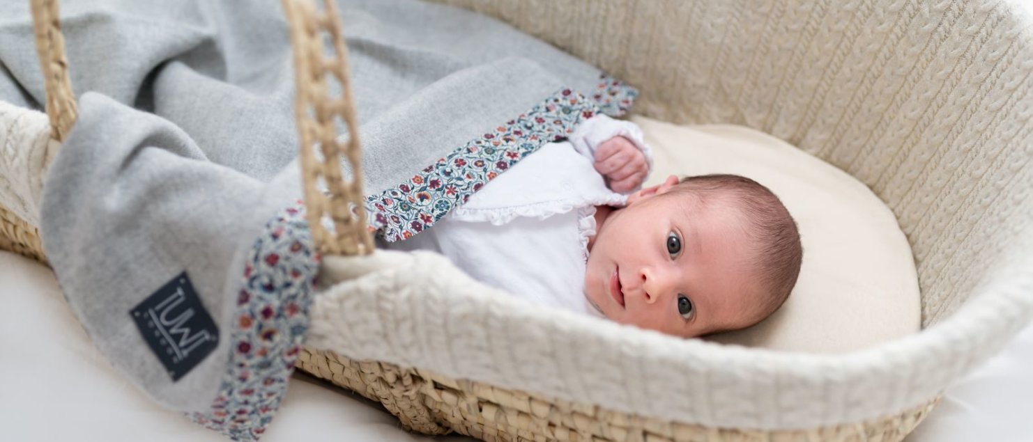 Baby in a basket with a Tuwi Blanket